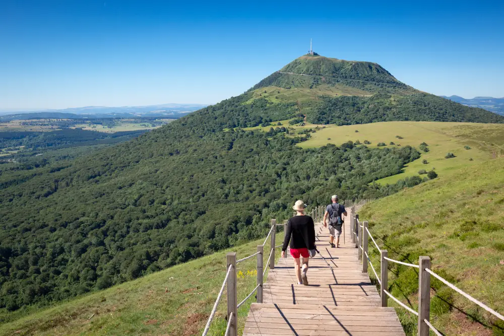 Randonneurs dans le massif central, l'été, par beau temps, avec vue sur le Puy de Dôme.