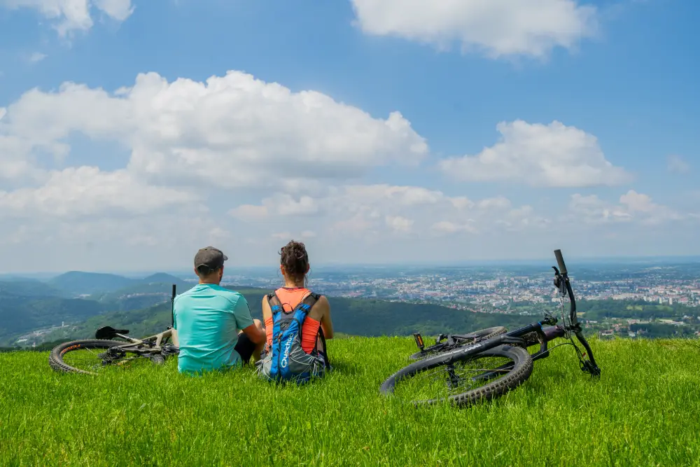 deux cycliste et leurs vélos, sur une colline avec vue sur Besançon