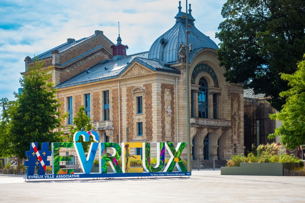 bâtiment en briques à Evreux dans l'Eure avec le nom de la ville en grosses lettres colorées.