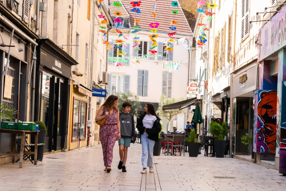 une femme et deux enfants dans une rue piétonne à Gray en Haute-Saône