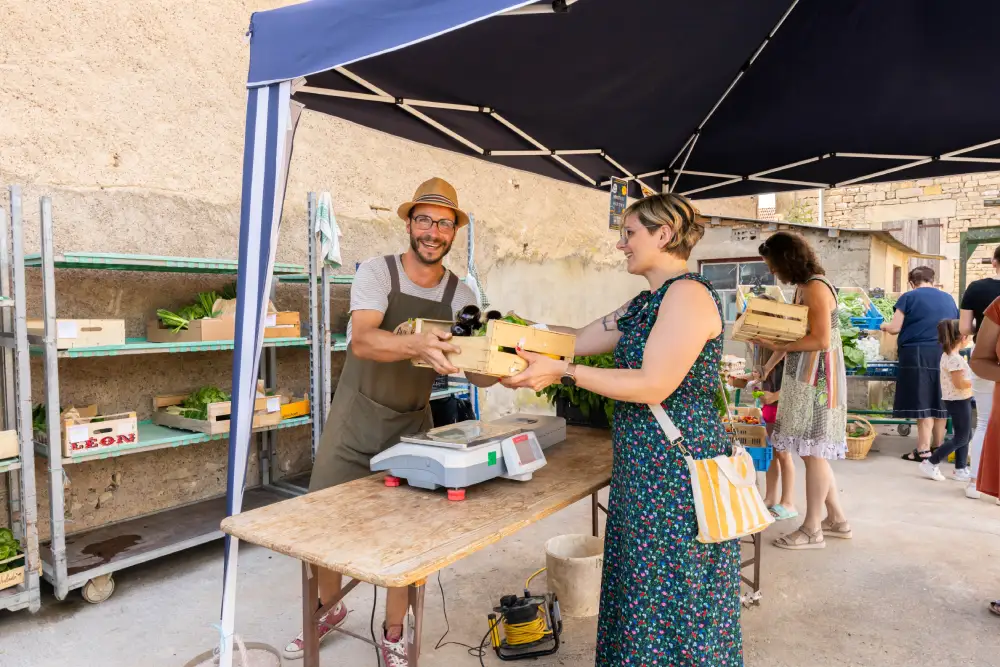 une femme qui achète des légumes au marché de Gy dans le pays graylois