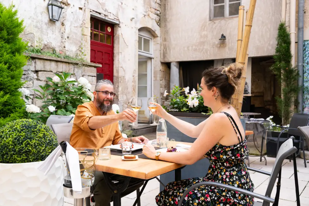 un couple en train de trinquer sur une terrasse à Gray