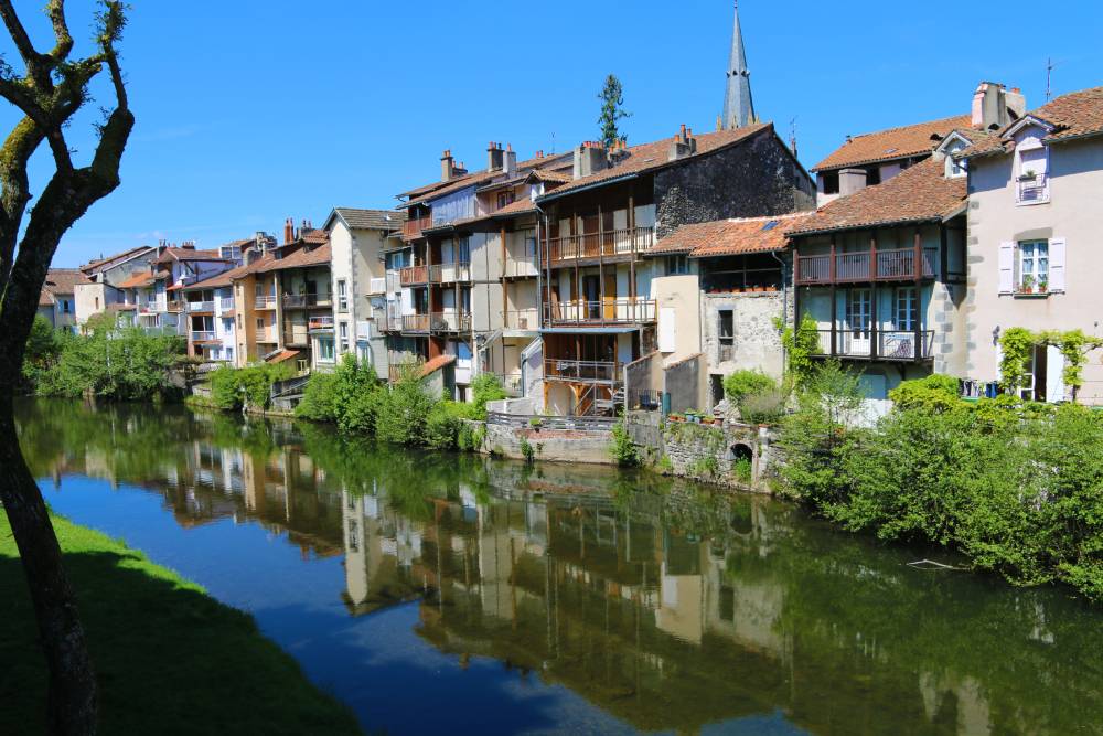 Les rives de la Jordanne à Aurillac, dans le Cantal avec des maisons qui se reflètent dans l'eau.